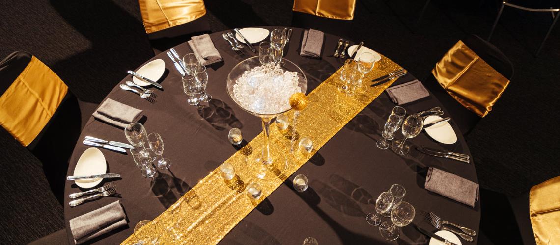 Function room table setting with gold table runner at Frankston Arts Centre