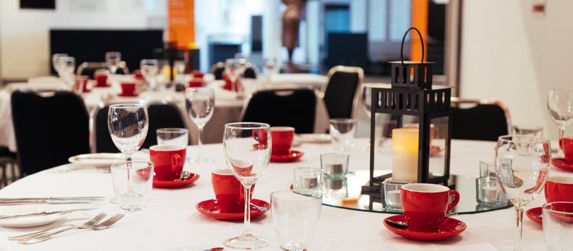Function room table settings with red coffee cups at Frankston Arts Centre