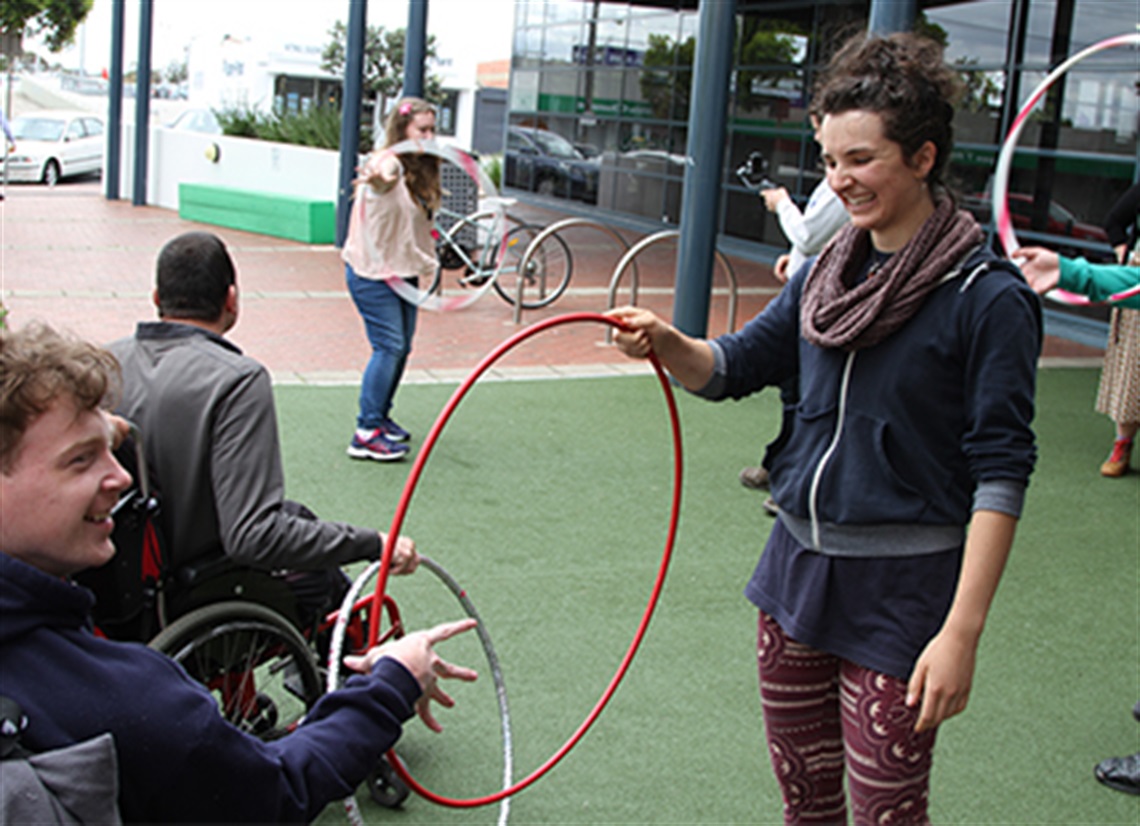 Circus on Wheels performer entertains accessibility onlookers with a hoop at Frankston Arts Centre